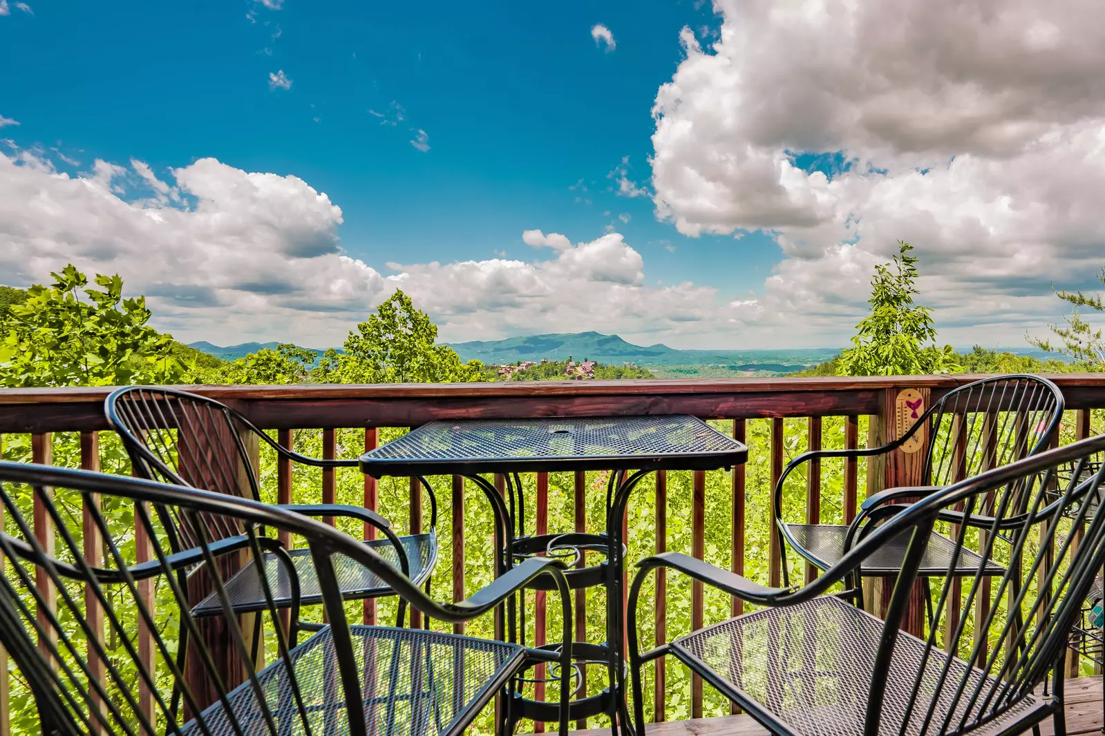 table and chairs on deck of 1 bedroom cabin with mountain view